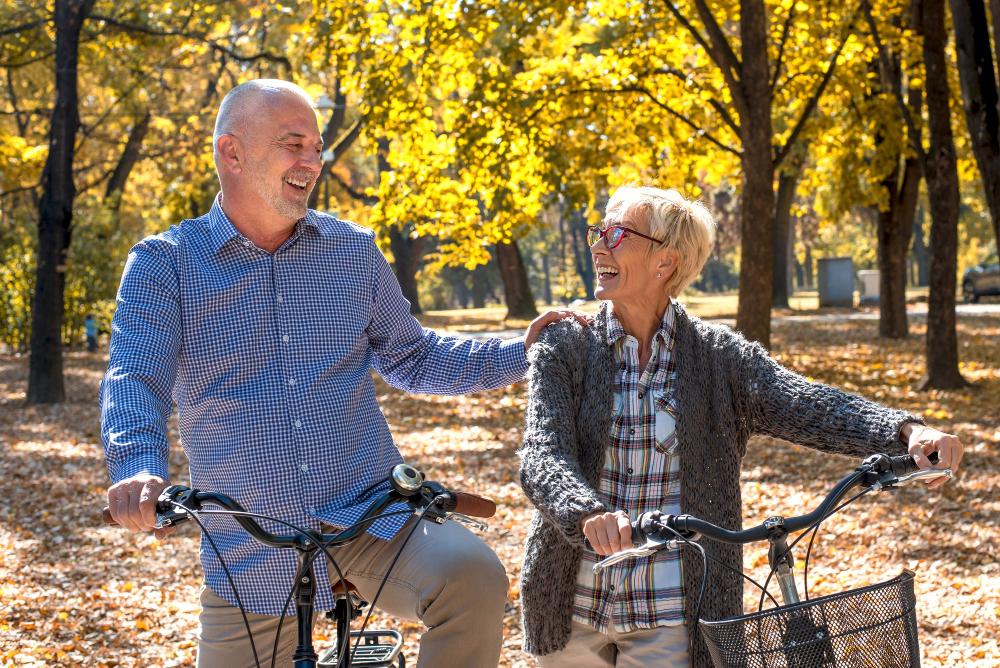 happy-elderly-couple-riding-bicycle-park-autumn