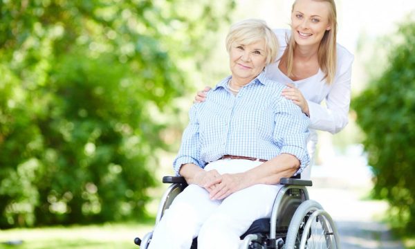 caregiver-pushing-senior-woman-wheelchair